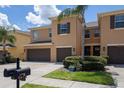 Inviting townhome with a two-car garage, manicured lawn, and a charming palm tree in a well maintained community at 9520 Trumpet Vine Loop, Trinity, FL 34655
