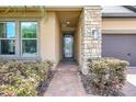 Inviting front entrance with stone accents, a decorative glass door, and manicured landscaping at 10415 Cardera Dr, Riverview, FL 33578