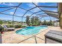 Stunning screened-in pool area with a spa, lake view, and ample lounge space at 10415 Cardera Dr, Riverview, FL 33578