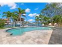 Inviting backyard pool area surrounded by lush landscaping and waterfront views at 106 Midway Is, Clearwater Beach, FL 33767
