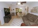 Comfortable living room featuring tile flooring, a ceiling fan, and a view into the sun room at 1126 Tarridon Ct, Dunedin, FL 34698
