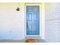 A stylish blue front door with sidelight is complemented by a palm tree-themed welcome mat at 12846 Tallowood Dr, Riverview, FL 33569
