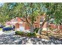 Beautiful pink townhome with mature trees, offering shade and curb appeal at 14561 El Paseo Dr, Seminole, FL 33776