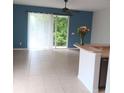 Bright living area features blue accent wall, tile floors, a ceiling fan, and sliding glass doors to outside at 1508 Talisker Dr, Clearwater, FL 33755