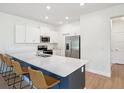 Modern kitchen featuring large island, white cabinets, stainless steel appliances, and barstool seating at 17729 Nectar Flume Dr, Land O Lakes, FL 34638
