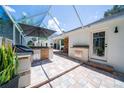 Outdoor kitchen area with built-in grill and bar, ideal for outdoor cooking and entertaining guests at 1903 Curry Rd, Lutz, FL 33549