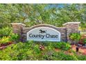 Elegant stone community entrance sign for Country Chase with lush landscaping and mature trees at 2078 Madrid N Ct, Clearwater, FL 33763
