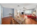 Bright living room with a glass dining table, hardwood floors, and open floorplan for easy entertaining at 2632 Tung Dr, Holiday, FL 34691