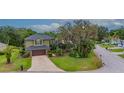 Aerial view of charming two-story home with mature trees, beautiful landscaping, and a long driveway at 2712 Spring Meadow Dr, Plant City, FL 33566