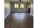 Spacious living room with wood-look flooring, natural light, and a ceiling fan at 2753 Countryside Blvd # 107, Clearwater, FL 33761