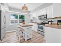 Bright kitchen featuring a center island with seating, stainless steel appliances and ample cabinet space at 2858 State Road 590, Clearwater, FL 33759