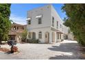 Stunning white stucco home with decorative accents, a gravel driveway, and lush greenery at 2936 W Knights Ave # A, Tampa, FL 33611