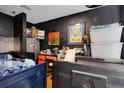 Cluttered bedroom featuring dark walls, a loft bed, and a variety of personal items and storage containers at 3008 Jackson N St, St Petersburg, FL 33704
