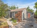 A charming home with gray siding, white trim, a coral door, and a paved driveway at 3305 10Th N Ave, St Petersburg, FL 33713