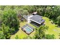 Expansive elevated home featuring a screened pool, lush landscaping, and detached carport at 35031 Shale St, Webster, FL 33597