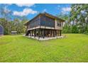 Raised home with a screened in porch and entertainment area beneath at 35031 Shale St, Webster, FL 33597