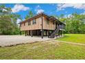 Elevated home with a screened in porch, stairs and gravel parking at 35031 Shale St, Webster, FL 33597