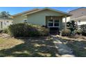 Front yard of single-story home with trimmed bushes and walkway to a covered porch at 3827 15Th N Ave, St Petersburg, FL 33713