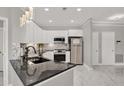 Kitchen featuring white cabinetry, granite counters, tile backsplash, and stainless steel appliances at 4333 Bayside Village Dr # 110, Tampa, FL 33615