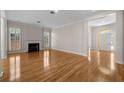 Spacious living room featuring hardwood floors, a fireplace, and an arched doorway leading to the front entrance at 4518 W Woodmere Rd, Tampa, FL 33609