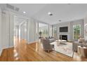 Bright living room with fireplace, hardwood floors, columns, and lots of natural light from the many windows at 4518 W Woodmere Rd, Tampa, FL 33609