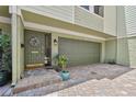 Warm entrance features an attached garage, brick paving, and a charming front door with decor at 511 Sandy Hook Rd, Treasure Island, FL 33706