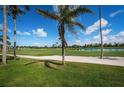 Picturesque view of a well-manicured golf course with palm trees, a serene lake, and clear blue skies at 6151 Bahia Del Mar Blvd # 126, St Petersburg, FL 33715