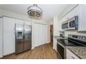 Bright kitchen with stainless steel appliances, granite countertops, white cabinets, and wood flooring at 6151 Bahia Del Mar Blvd # 126, St Petersburg, FL 33715