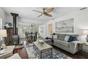 Open-concept living room with a wood-burning stove, dining area, hardwood floors, and stylish furnishings at 670 Wooddell Dr, Safety Harbor, FL 34695