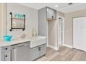 Bright kitchen featuring modern fixtures, an apron sink, and stylish wood-look flooring at 7208 S Juanita St, Tampa, FL 33616