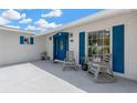 Charming front porch with rocking chairs and a striking blue door at 8314 Stillbrook Ave, Tampa, FL 33615