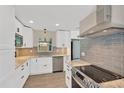 Modern kitchen with stainless steel appliances, granite countertops, and stylish gray backsplash at 8314 Stillbrook Ave, Tampa, FL 33615