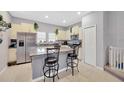 Well-lit kitchen with stainless steel appliances, granite countertops, and a breakfast bar with stools at 842 Tennyson Mill Cir, Tampa, FL 33619