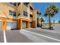 Exterior view of condo garages and adjacent parking, with stairway access to upper levels at 10764 70Th Ave # 5302, Seminole, FL 33772