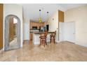 Kitchen featuring an island with barstool seating, stainless steel appliances, and tan and brown tile flooring at 10764 70Th Ave # 5302, Seminole, FL 33772