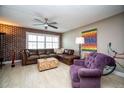 View of a well-decorated living room featuring a ceiling fan, brick accent wall, and sectional sofa at 12300 Park Blvd # 222, Seminole, FL 33772
