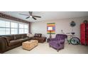 View of a well-decorated living room featuring a ceiling fan, brick accent wall, and sectional sofa at 12300 Park Blvd # 222, Seminole, FL 33772