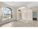 Bright entryway featuring tile flooring, large windows, elegant columns, and a decorative chandelier at 12339 Roseland Dr, New Port Richey, FL 34654