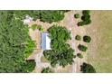 Aerial view of the house with white roof surrounded by trees and grass at 12434 Cody Dr, Wimauma, FL 33598