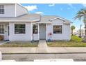 Inviting townhouse exterior with gray siding, neat landscaping, and a welcoming entrance with plants in pots at 12648 Castle Hill Dr, Tampa, FL 33624