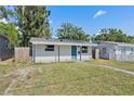 Charming single-story home with a blue front door, solar panels, and freshly painted siding at 1310 43Rd S St, St Petersburg, FL 33711