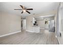 Bright and spacious living room with modern flooring, ceiling fan, and an open layout to the kitchen at 1310 43Rd S St, St Petersburg, FL 33711