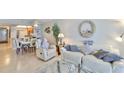 Bright and airy living area with open layout, tile floors, stylish furniture, and views of the dining area and kitchen at 13720 Gulf Blvd # 302, Madeira Beach, FL 33708