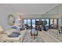 Relax in this inviting living room with ocean views, neutral colors, comfortable seating, and a decorative seashell wreath at 13720 Gulf Blvd # 302, Madeira Beach, FL 33708