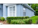 Exterior detail of the home showing well-maintained landscaping and a light blue facade at 14116 Whitecap Ave, Hudson, FL 34667