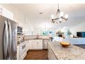 Bright, modern kitchen featuring stainless steel appliances and granite countertops, open to the living room at 14902 Foxhound Pl, Tampa, FL 33624