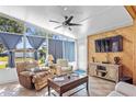 Bright sun room with floor to ceiling windows, comfortable seating, and decorative wood paneling at 1701 66Th N Ave, St Petersburg, FL 33702