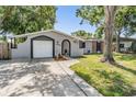 Attractive single-story home with tidy landscaping, a driveway, and a charming arched entryway at 1708 Julian Lane Dr, Tampa, FL 33619