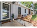 Cozy front porch features wicker chairs, potted plants, and a decorative front door at 1708 Julian Lane Dr, Tampa, FL 33619