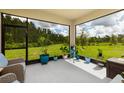 Inviting screened porch with views of a well maintained lawn and wooded area, perfect for relaxing outdoors at 17263 Mango Shay Ct, Land O Lakes, FL 34638